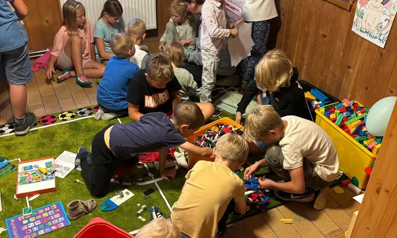 Dzieci bawią się razem na dywanie podczas oazy rodzin