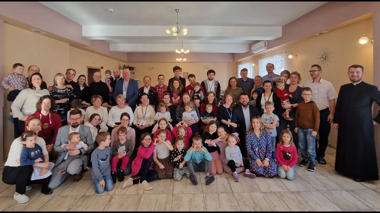 Wspólne zdjęcie rodzin z dziećmi i księdzem na rekolekcjach w Kiczorach