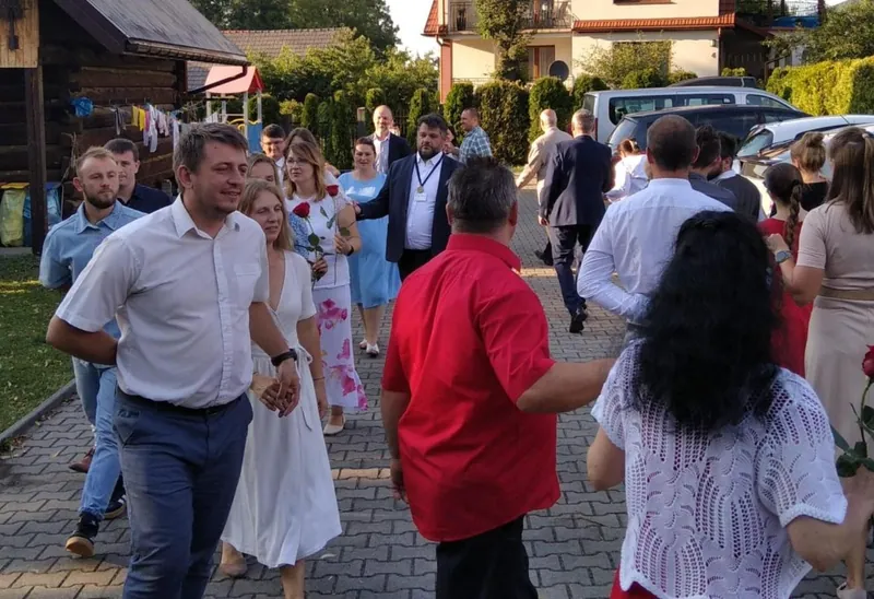 Uśmiechnięte pary idą razem, kobiety z różami w dłoniach